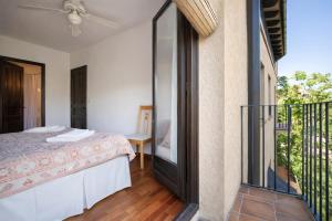 a bedroom with a bed and a balcony at Apartament amb vistes al castell - Cal Martí in Montsonis +35 photos