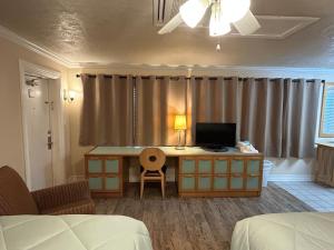 a bedroom with a desk with a computer on it at Sea Vista Motel in New Smyrna Beach