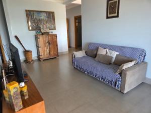 a living room with a couch and a tv at Rancho dos Ipês Corumbá in Alexânia