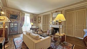 a living room with a couch and a fireplace at Château de la Chabroulie in Isle