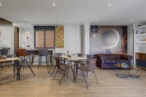 a room with a table and chairs and a couch at Albergue La Santa Siesta in Villadangos del Páramo