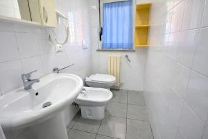 a white bathroom with a sink and a toilet at Appartamenti La Mer in San Benedetto del Tronto +11 photos