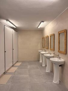 a row of sinks and mirrors in a bathroom at LITTLE Hostel in Puerto de Sagunto
