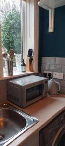 a microwave sitting on a kitchen counter next to a sink at spacious self-contained accommodation 135 cantebury road Herne bay CT6 5RZ in Kent
