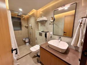 a bathroom with a sink and a toilet and a mirror at Lalit hotel in Udaipur