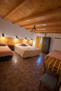 a bedroom with two beds and a wooden ceiling at Hotel Sante in Tinogasta +71 photos