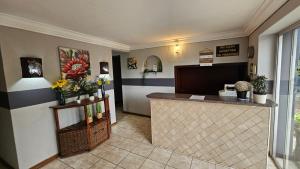 a lobby with a counter with flowers and plants at Honey Bee Guesthouse in Rustenburg