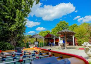 a playground with a pool table and umbrellas at Hôtel La Palmeraie in Toulouse
