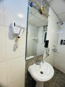 Vantage View - 2BHK Apartment في Nalmatha: حمام أبيض اللون مزود بحوض ومِرآة