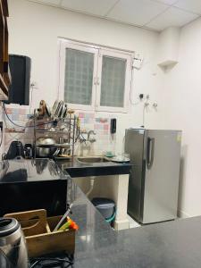 Vantage View - 2BHK Apartment في Nalmatha: مطبخ مزود بحوض ومبرد