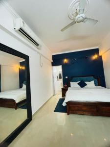 Vantage View - 2BHK Apartment في Nalmatha: غرفة نوم بها سريران ومرآة كبيرة +صورة واحدة