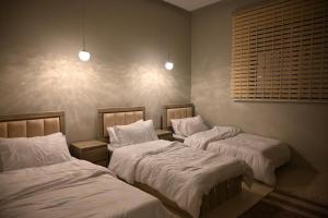 two beds in a room with white sheets at شاليه لانتانا in Taif +110 photos