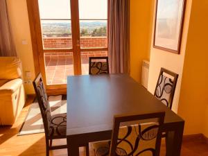 a dining room with a table and chairs and a window at Fuenteberros 1 in Golmayo