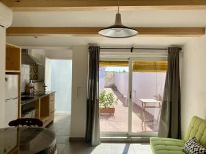 a kitchen with a sliding glass door leading to a patio at Casa Taller en Penelles in Penellas +14 photos