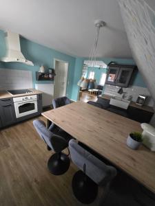 eine Küche mit einem Holztisch und einigen Stühlen in der Unterkunft Haus Erdmann in Dahn