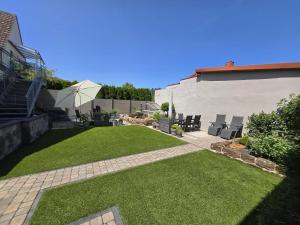 ein Hinterhof mit grünem Gras und einer Terrasse in der Unterkunft Haus Erdmann in Dahn