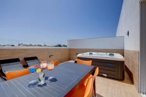 a dining room with a blue table and orange chairs at Bayside A Apartments in St. Julianʼs