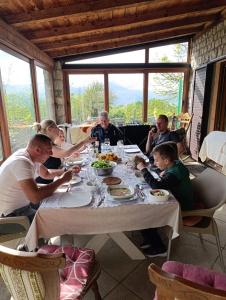 a group of people sitting at a table eating food at Vila Pegaz in Virpazar