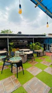 an outdoor patio with tables and chairs and grass at Garden Atlantis Hotel in Enugu