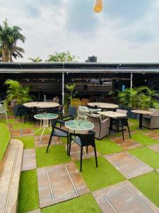 a patio with tables and chairs and grass at Garden Atlantis Hotel in Enugu