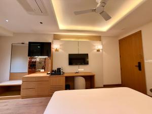 a bedroom with a bed and a desk and a tv at Lalit hotel in Udaipur +18 photos