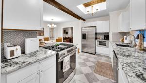 a large kitchen with white cabinets and marble counter tops at In-ground pool, hot tub, fire pit, massage room! in Tulsa
