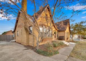 a brick house with a tree in front of it at In-ground pool, hot tub, fire pit, massage room! in Tulsa