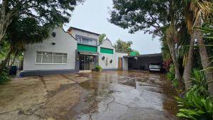 a driveway in front of a white house at Honey Bee Guesthouse in Rustenburg