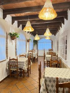 a dining room with tables and chairs and chandeliers at AIRE Vejer - recién reformado 2026 in Vejer de la Frontera