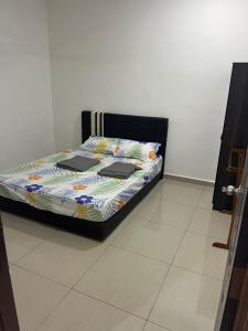 a bed with two laptops on it in a room at SaiMurni Homestay in Jerantut