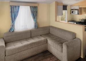 a couch in a living room with a window at Towervans Caravan Park in Mablethorpe