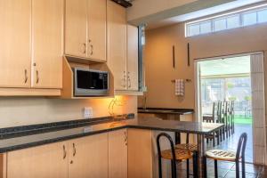 a kitchen with wooden cabinets and a table and chairs at Pearlstone in Durban