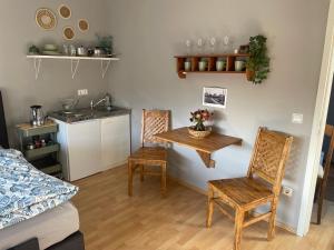 a room with a table and two chairs and a kitchen at Gemütliches Appartement Köln in Cologne