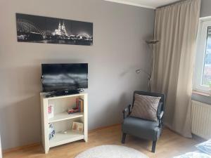 a living room with a chair and a television at Gemütliches Appartement Köln in Cologne