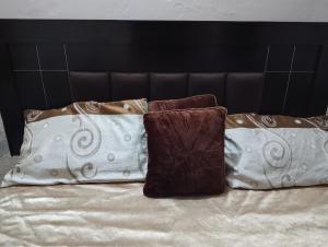 a group of pillows sitting on top of a bed at Suites Inn in Faisalabad +4 photos