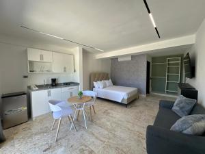 a living room with a couch and a table and a kitchen at Arena Aparta Hotel in Punta Cana