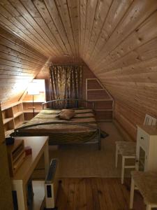 a bedroom with a bed in a wooden room at Tammetalu puhkemaja in Nõmme +22 photos
