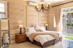 a bedroom with a large bed and a large window at Pearlstone in Durban +17 photos