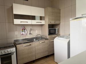 a small kitchen with a sink and a refrigerator at Apartamento Sunset 101 in Palhoça