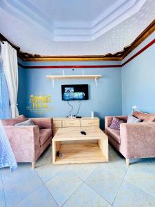 a living room with two couches and a table at BKK Residences in Fort Portal