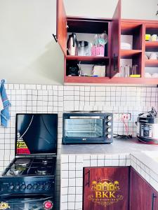 a kitchen with a stove and a microwave at BKK Residences in Fort Portal