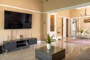 a living room with a flat screen tv on the wall at Pearlstone in Durban
