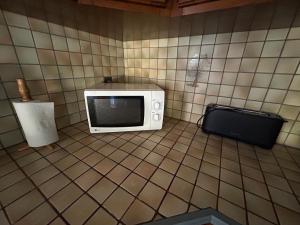 a microwave sitting on the corner of a kitchen at Le gîte a momo in Annoire