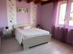 a bedroom with a bed with pink walls and windows at Le gîte a momo in Annoire