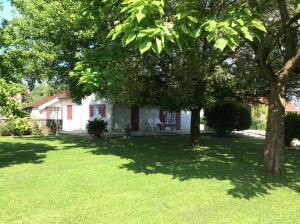 a white house with a tree in the yard at Le gîte a momo in Annoire