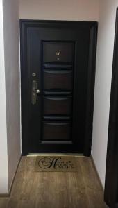 a black door with a sign in front of it at Апартамент Аксел in Panagyurishte