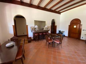 a living room with tables and chairs and a kitchen at Casa Vale da Serra - Petrópolis in Petrópolis