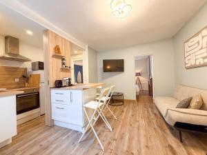 a kitchen and living room with a couch and a table at Les Volets Bleus in Chartres +5 photos