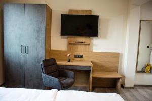 a bedroom with a desk with a television and a chair at Bärenhof in Matzen