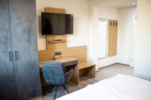 a bedroom with a desk and a tv and a bed at Bärenhof in Matzen